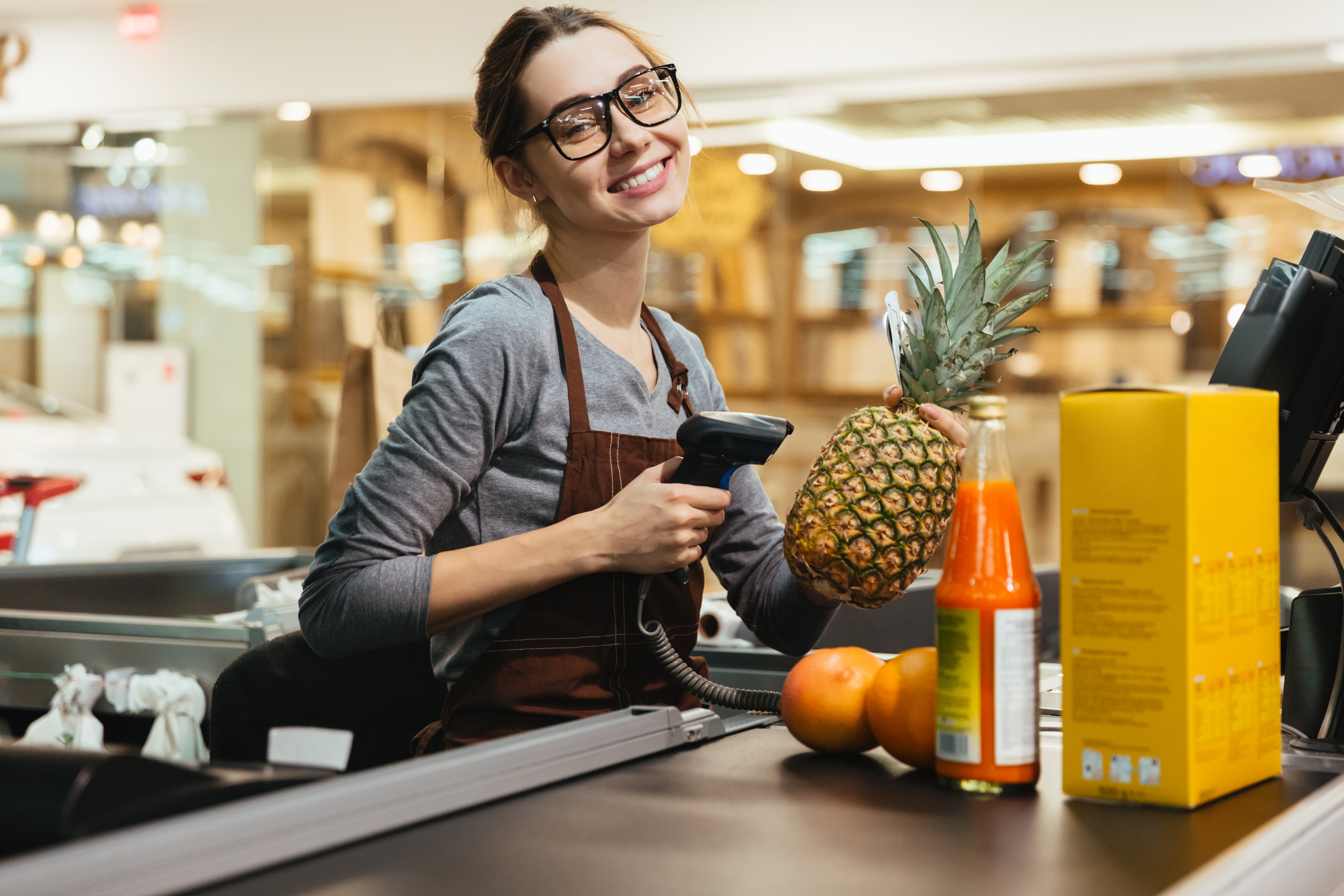 happy-female-cashier-scanning-grocery-items-1.jpg